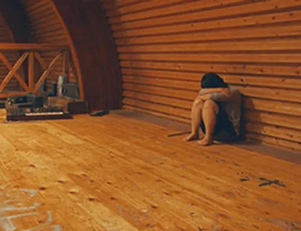 校舎の隅で体育座りで落ち込んでいることみさんの写真